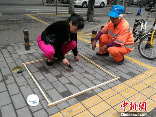 圖為檢查人員在標準范圍收集塵土稱重。　張梟 攝