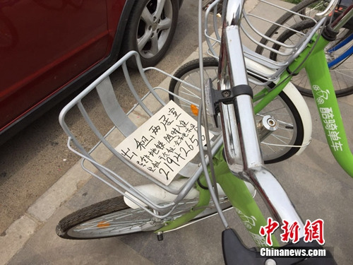 某品牌共享單車車筐內被貼上了手寫的“出租房屋”小廣告。中新網 吳濤 攝