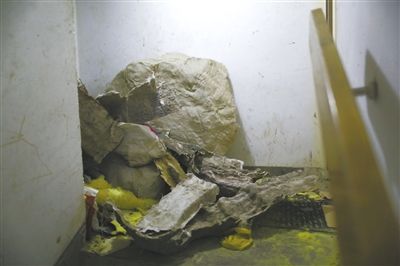 昨日,人濟山莊“最牛違建”的假山已開始拆除,拆下的大量材料堆滿樓道,樓下搭起安全通道,供小區居民進出(圖)。新京報記者 浦峰 攝