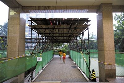 昨日,人濟山莊“最牛違建”的假山已開始拆除,拆下的大量材料堆滿樓道,樓下搭起安全通道,供小區居民進出(圖)。新京報記者 浦峰 攝