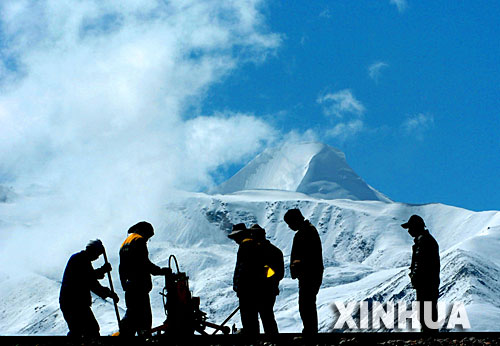 青藏鐵路建設者在西藏桑典康桑雪山腳下整道(2005年6月8日攝)。 青藏鐵路從西寧至拉薩全長1956公里,是世界上海拔最高、線路最長、穿越凍土里程最長的高原鐵路。把鐵路修進西藏是幾代中國人的夢想,但這一想法直到新中國成立後才逐漸變為現實。青藏鐵路一期工程西寧至格爾木段于1958年開工,1984年交付營運。但限于當時國家的經濟實力以及高原、凍土等築路技術難題尚未解決,格爾木至拉薩段被迫停建。2001年6月,國家總投資330.9億元動工修建青藏鐵路二期工程。這一工程跨越昆侖山、唐古拉山,通過多年凍土層和大片“生命禁區”,是人類鐵路建設史上亙古未有的穿越。它的建成將為神秘而古老的青藏高原帶來新的生機和活力! 新華社發