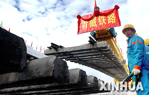 一名青藏鐵路建設者正在指揮鋪軌。2005年8月24日,隨著青藏鐵路在海拔5072米處成功鋪軌,中國人創造了世界鐵路最高點的紀錄(資料照片)。 青藏鐵路從西寧至拉薩全長1956公里,是世界上海拔最高、線路最長、穿越凍土里程最長的高原鐵路。把鐵路修進西藏是幾代中國人的夢想,但這一想法直到新中國成立後才逐漸變為現實。青藏鐵路一期工程西寧至格爾木段于1958年開工,1984年交付營運。但限于當時國家的經濟實力以及高原、凍土等築路技術難題尚未解決,格爾木至拉薩段被迫停建。2001年6月,國家總投資330.9億元動工修建青藏鐵路二期工程。這一工程跨越昆侖山、唐古拉山,通過多年凍土層和大片“生命禁區”,是人類鐵路建設史上亙古未有的穿越。它的建成將為神秘而古老的青藏高原帶來新的生機和活力! 新華社發