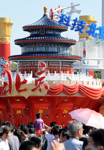 10月2日,遊客在“北京之歌”彩車前參觀留影。 據了解,在10月1日國慶群眾遊行中出現的彩車將從2日至7日在天安門廣場進行展示。這些彩車充分展示出新中國成立60年來取得的輝煌成就,表達了56個民族的群眾對偉大祖國的衷心祝福。 新華社記者 唐召明 攝